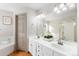 A bathroom boasting double sinks and a shower and tub combo behind a half wall at 1832 S Tamarac St, Denver, CO 80231