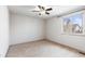 Bedroom featuring neutral carpet, white walls, ceiling fan, and a window at 1832 S Tamarac St, Denver, CO 80231