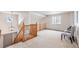 Upstairs hallway featuring natural wood railing and neutral colored carpet at 1832 S Tamarac St, Denver, CO 80231