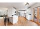 Modern kitchen with white cabinetry, stainless steel appliances, and hardwood flooring with view to dining area at 1832 S Tamarac St, Denver, CO 80231