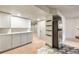 Basement kitchenette featuring white cabinets, stainless steel refrigerator, and decorative floors at 1832 S Tamarac St, Denver, CO 80231