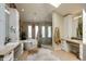 Bright bathroom with a soaking tub, glass-enclosed shower, dual sinks, and ample natural light from a skylight at 460 Garfield St, Denver, CO 80206