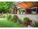 Home's exterior featuring manicured landscaping, a stone wall, green lawn, and a covered patio area at 460 Garfield St, Denver, CO 80206
