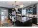 Modern kitchen features stainless steel appliances, dark cabinetry, an island with seating, and stylish pendant lighting at 460 Garfield St, Denver, CO 80206