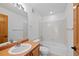 Bright bathroom featuring a tub with white tile surround and a vanity with wood cabinets and a neutral countertop at 7879 S Zante Ct, Aurora, CO 80016