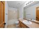Bathroom showcasing a vanity with a light-toned countertop, a tub with a tiled surround, and wood-finished doors at 7879 S Zante Ct, Aurora, CO 80016