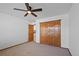 Bedroom with wooden closet doors, neutral carpet, and ceiling fan at 7879 S Zante Ct, Aurora, CO 80016