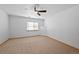Bright, carpeted bedroom featuring a ceiling fan and a large window at 7879 S Zante Ct, Aurora, CO 80016
