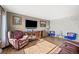 Bright living room featuring wood floors, decorative stone wall, and comfortable seating at 13225 W Jewell Cir, Lakewood, CO 80228