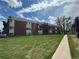 Lush lawn of brick apartment complex with walkways, landscaping, and building access at 3613 S Sheridan Blvd # 16, Denver, CO 80235
