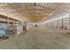 Wide shot of the inside of the barn featuring a packed dirt floor and wood beam ceiling at 402 S County Road 129, Bennett, CO 80102