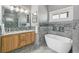 Elegant bathroom with a soaking tub, double vanity, and mosaic tile at 402 S County Road 129, Bennett, CO 80102