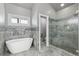 Elegant bathroom with soaking tub, glass shower, and tile at 402 S County Road 129, Bennett, CO 80102