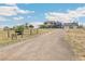 Two-story home with a long gravel driveway and attached garage at 402 S County Road 129, Bennett, CO 80102