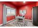 Home office with red walls, a writing desk, and built-in cabinetry at 402 S County Road 129, Bennett, CO 80102