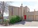 Modern townhome with a red front door and attached one car garage in a landscaped neighborhood at 8917 E Chenango Ave, Greenwood Village, CO 80111