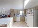 Well-lit kitchen with modern appliances, a white refrigerator, and ample cabinet space at 8917 E Chenango Ave, Greenwood Village, CO 80111