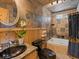 Unique bathroom featuring stone tiled walls, a dark vessel sink and a soaking tub at 451 Harris Dr, Idaho Springs, CO 80452