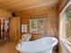 Wood-paneled bathroom showcasing a freestanding tub with vintage-style fixtures at 451 Harris Dr, Idaho Springs, CO 80452