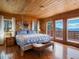 Serene bedroom with wooden accents, a wrought-iron bed, and a scenic view from multiple windows at 451 Harris Dr, Idaho Springs, CO 80452