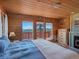 Cozy bedroom boasts wood walls, mountain view windows, and a white iron canopy bed at 451 Harris Dr, Idaho Springs, CO 80452