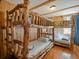 Charming bunk room featuring wooden bunk beds with log details and hardwood floors at 451 Harris Dr, Idaho Springs, CO 80452