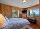 Comfortable bedroom features wood paneled walls and mountain views at 451 Harris Dr, Idaho Springs, CO 80452
