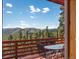 Open deck with views of mountains and trees offers a relaxing outdoor dining space at 451 Harris Dr, Idaho Springs, CO 80452