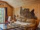 Relaxing living room with warm wood paneling, a leather sofa, and natural light from a side window at 451 Harris Dr, Idaho Springs, CO 80452