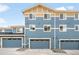 Exterior shot of multi-Gathering home featuring multiple garage doors and ample parking space at 883 Widgeon Cir, Longmont, CO 80503