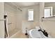Bright bathroom featuring a tiled shower-tub combination, a window, and a stylish sink with a dark faucet at 505 Empire St, Aurora, CO 80010