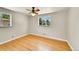 Comfortable bedroom featuring hardwood floors, a ceiling fan, and abundant natural light from two windows at 505 Empire St, Aurora, CO 80010