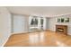 Sunlit living room featuring hardwood floors, fireplace, and large windows with sheer curtains at 505 Empire St, Aurora, CO 80010