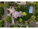 An aerial view of the house showcasing a pristine lawn, pickleball court, and surrounding lush landscaping at 7050 S Polo Ridge Dr, Littleton, CO 80128