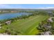Stunning aerial view of waterfront property with large grassy field and mature landscaping at 7050 S Polo Ridge Dr, Littleton, CO 80128