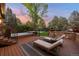 Cozy backyard deck with sun loungers, a hot tub, and lush landscaping perfect for relaxation at 7050 S Polo Ridge Dr, Littleton, CO 80128