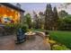 Backyard patio with a stone fire pit and Adirondack chairs, perfect for outdoor entertaining at 7050 S Polo Ridge Dr, Littleton, CO 80128