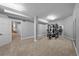 View of a finished basement space with carpet flooring and a full weight rack gym with doorway to another room at 7050 S Polo Ridge Dr, Littleton, CO 80128