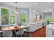 Inviting breakfast nook featuring a custom banquette, wood table, and natural light from the surrounding windows at 7050 S Polo Ridge Dr, Littleton, CO 80128
