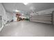 Spacious three car garage with epoxy flooring, garage door opener, side entrance, and plenty of storage space at 7050 S Polo Ridge Dr, Littleton, CO 80128