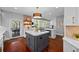 A spacious kitchen featuring an island, modern lighting, stainless steel appliances, and access to the outdoor patio at 7050 S Polo Ridge Dr, Littleton, CO 80128