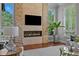 Contemporary living room featuring a stone fireplace, large windows, and modern decor at 7050 S Polo Ridge Dr, Littleton, CO 80128