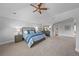 Serene main bedroom boasts a vaulted ceiling, plush carpet, ceiling fan, and large windows with tree views at 7050 S Polo Ridge Dr, Littleton, CO 80128