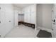 Bright mudroom with white cabinets, bench seating, storage baskets, and light neutral paint at 7050 S Polo Ridge Dr, Littleton, CO 80128