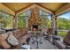 Cozy outdoor living area featuring a stone fireplace, comfortable seating, and a serene setting at 7050 S Polo Ridge Dr, Littleton, CO 80128