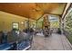 Inviting outdoor patio features a stone fireplace, comfortable seating, ceiling fan, and an elegant wrought iron table set at 7050 S Polo Ridge Dr, Littleton, CO 80128