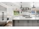 Modern kitchen featuring an island with seating, stainless steel appliances, and white cabinetry at 39 Sedgwick Dr, Cherry Hills Village, CO 80113