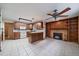 Open floor plan showcasing the kitchen with wood cabinets, granite countertops, and a fireplace in the living area at 205 Coral Way, Broomfield, CO 80020