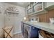 Bright laundry room featuring a gray countertop with a light blue accent backsplash and modern washer and dryer at 145 Kettle Valley Way, Monument, CO 80132