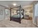 This spacious bedroom features a four-poster bed, neutral carpeting, and a sliding barn door to the bathroom at 145 Kettle Valley Way, Monument, CO 80132